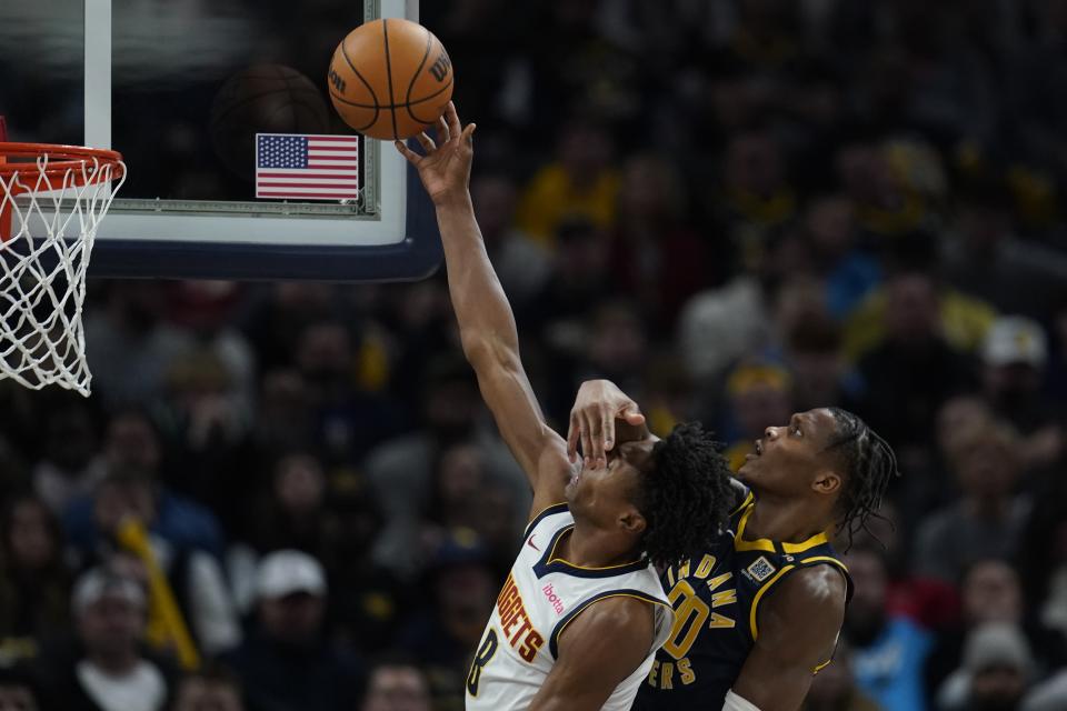 Denver Nuggets' Peyton Watson shoots against Indiana Pacers' Bennedict Mathurin (00) during the second half of an NBA basketball game, Tuesday, Jan. 23, 2024, in Indianapolis. (AP Photo/Darron Cummings)