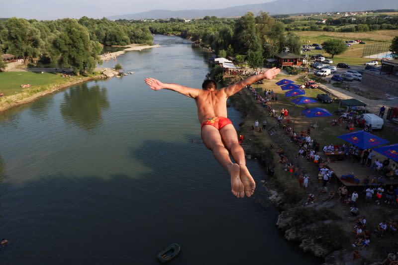 Divers jump into a river from a bridge in Kosovo