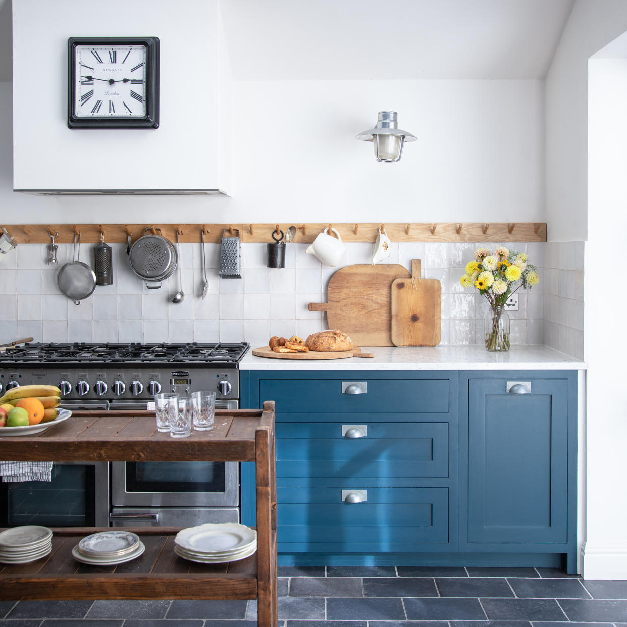  Blue kitchen with peg wall rail, slate floor tiles and crittal-style french doors. 