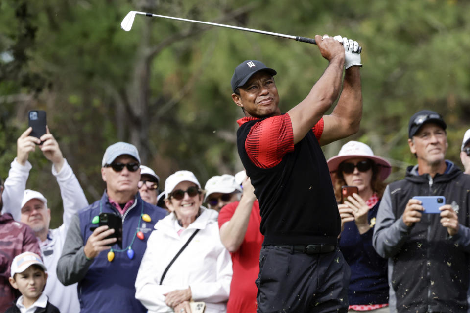 FILE - Tiger Woods tees off on the 4th hole during the final round of the PNC Championship golf tournament Sunday, Dec. 18, 2022, in Orlando, Fla. Woods is back at Riviera, this time with more on his plate than handing out the trophy in the Genesis Invitational. He returns to the PGA Tour for the first time since July. (AP Photo/Kevin Kolczynski, File)