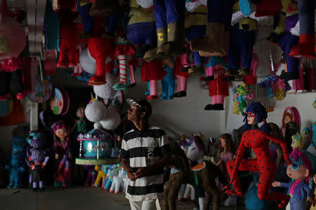 A man looks at pinatas at a birthday supplies shop in Caracas, Venezuela, March 20, 2019. The manager of the shop said, "People were coming after work or early on Saturdays to buy birthday supplies. Now few people come." REUTERS/Ivan Alvarado