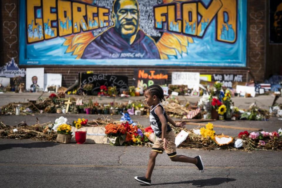 Carter Sims, 3, of Pine Island, Minn., runs past a mural at the George Floyd memorial outside Cup Foods, Thursday, June 25, 2020, in Minneapolis. Floyd, a Black handcuffed man, died May 25 after Derek Chauvin, a white officer, pressed his knee into Floyd’s neck for nearly 8 minutes and held it there even after Floyd said he couldn’t breathe and stopped moving. (Leila Navidi/Star Tribune via AP)