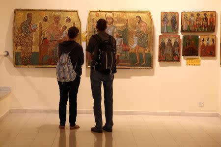 Tourists look at icons which were recovered by Cyprus after being stolen in the aftermath of Turkey's invasion in 1974, in a museum in Nicosia, Cyprus May 19, 2017. REUTERS/Yiannis Kourtoglou