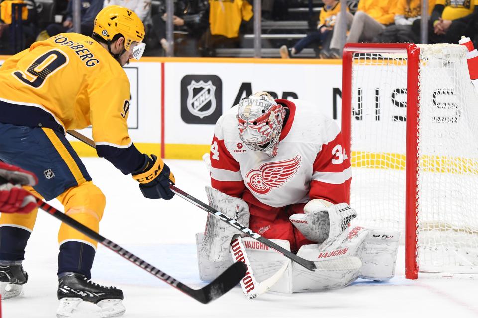 Detroit Red Wings goaltender Alex Lyon (34) makes a save on a shot by Nashville Predators left wing Filip Forsberg (9) during the first period at Bridgestone Arena in Nashville, Tennessee, on Saturday, March 23, 2024.