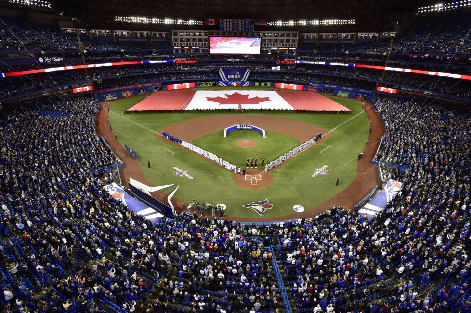 FILE - Members of the Toronto Blue Jays and the Detroit Tigers lineup before an opening day baseball game at Rogers Centre in Toronto, in this Thursday, March 28, 2019, file photo. Talks between the Toronto Blue Jays and the Canadian government have accelerated significantly and an exemption on border restrictions that would allow them to play in Canada starting July 30 may be possible, an official familiar with the talks told The Associated Press on Friday, July 16, 2021. (Frank Gunn/The Canadian Press via AP, File)