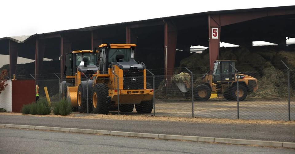 Heavy equipment removes fire damaged hay Monday morning from under outdoor storage following a weekend fire at the Nen-Noh Hay Inc. cubing facility in the Port of Pasco’s Big Pasco Industrial area.