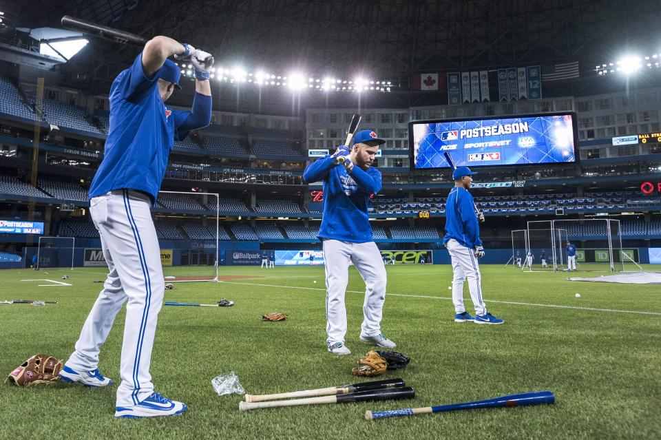 FILE - In this Oct. 7, 2015, file photo, Toronto Blue Jays Russell Martin, center, and Troy Tulowitzki, left, prepare to take batting practice during a team workout at the Rogers Centre in Toronto. All 30 Major League Baseball teams will train at their regular-season ballparks for the pandemic-shortened season after the Blue Jays received a Canadian federal government exemption on Thursday, July 2, 2020, to work out at Rogers Centre. Toronto will move camp from its spring training complex in Dunedin, Fla., where players reported for intake testing. The Blue Jays will create a quarantine environment at Rogers Centre and the adjoining Toronto Marriott City Centre Hotel which overlooks the field. (Darren Calabrese/The Canadian Press via AP, File)