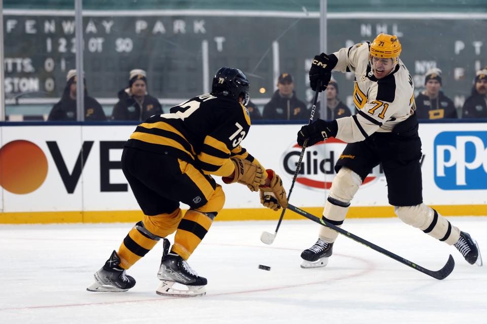 Pittsburgh Penguins' Evgeni Malkin (71) shoots past Boston Bruins' Charlie McAvoy (73) during the second period of the NHL Winter Classic hockey game, Monday, Jan. 2, 2023, at Fenway Park in Boston. (AP Photo/Michael Dwyer)