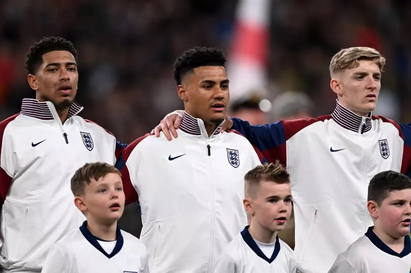 Jude Bellingham, Ollie Watkins and Anthony Gordon sing the national anthem prior to the international friendly match between England and Brazil.