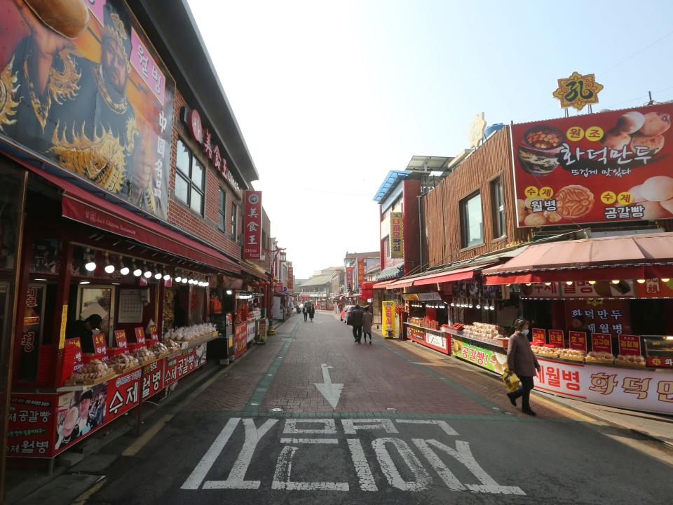 In this Feb. 14, 2020, photo, a woman wearing a face mask walks on a almost empty street at the Chinatown in Incheon, South Korea. Even as cases and deaths from the new virus mount, fear is advancing like a tsunami - and not just in the areas surrounding the Chinese city of Wuhan, the center of the outbreak that has been declared a global health emergency. A restaurant owner in the Chinatown says visitors have dropped by 90%. (AP Photo/Ahn Young-joon)