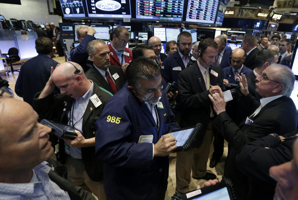 Nicholas Brigandi, right, managing director of NYSE floor operations, works with traders at the post that handles Enservco Corp., on the floor of the New York Stock Exchange, Friday, June 20, 2014. Stocks held on to small gains, enough to mark the latest record high closes for major indexes. (AP Photo/Richard Drew)