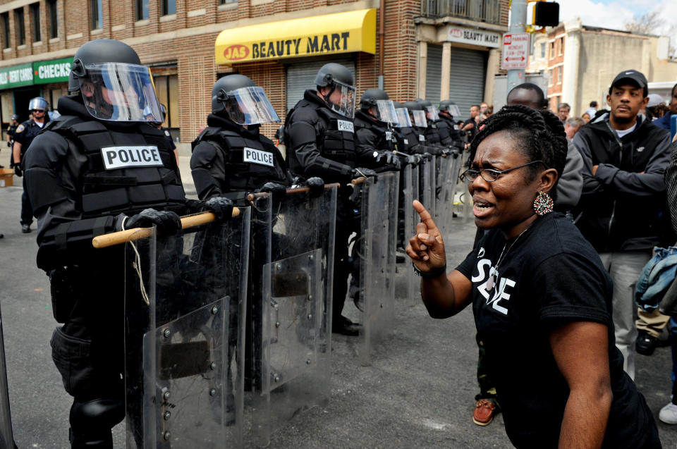 BALTIMORE, MD- APRIL 28: (R) Camille Lattimore-Weanquoi points her finger at officers lining the street where a peaceful gathering was taking place. There was a heavy police presence in some parts of the city today. These officers lined the street on W. North Ave. the scene of much looting. (Photo by Michael S. Williamson/The Washington Post via Getty Images)