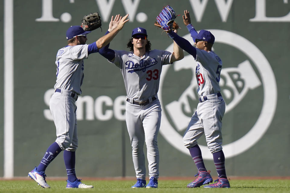 Los Angeles Dodgers' Chris Taylor, left, James Outman, center, and Mookie Betts, right, celebrate after the Dodgers beat the Boston Red Sox in a baseball game, Sunday, Aug. 27, 2023, in Boston. (AP Photo/Steven Senne)