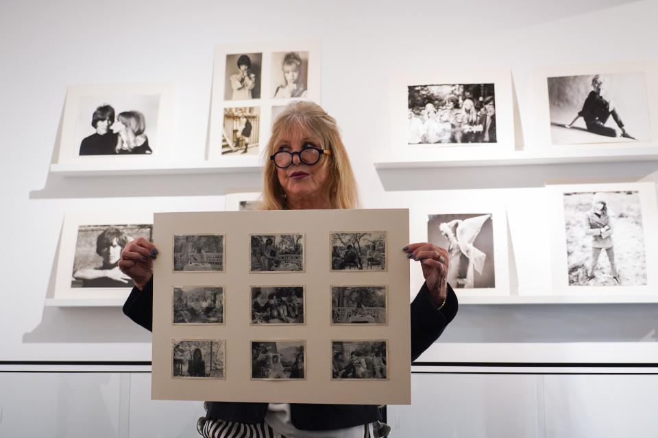 Pattie Boyd holds a set of pictures she took during the Beatles travel in India from The Pattie Boyd Collection, at Christie's, in London, Thursday, March 14, 2024. The photographs are estimated to sell within a range of £3,000-5,000. (AP Photo/Alberto Pezzali)