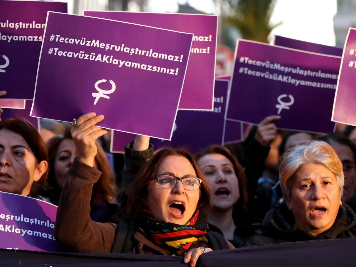 Turkish female protesters shout slogans against the government while holding placards reading 'Rape cannot be legalised': EPA