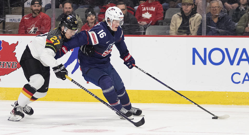 United States' Chaz Lucius (16) keeps Germany's Julian Waser (27) away as he carries the puck during second-period IIHF world junior hockey championships quarterfinal match action in Moncton, New Brunswick, Monday, Jan. 2, 2023. (Ron Ward/The Canadian Press via AP)