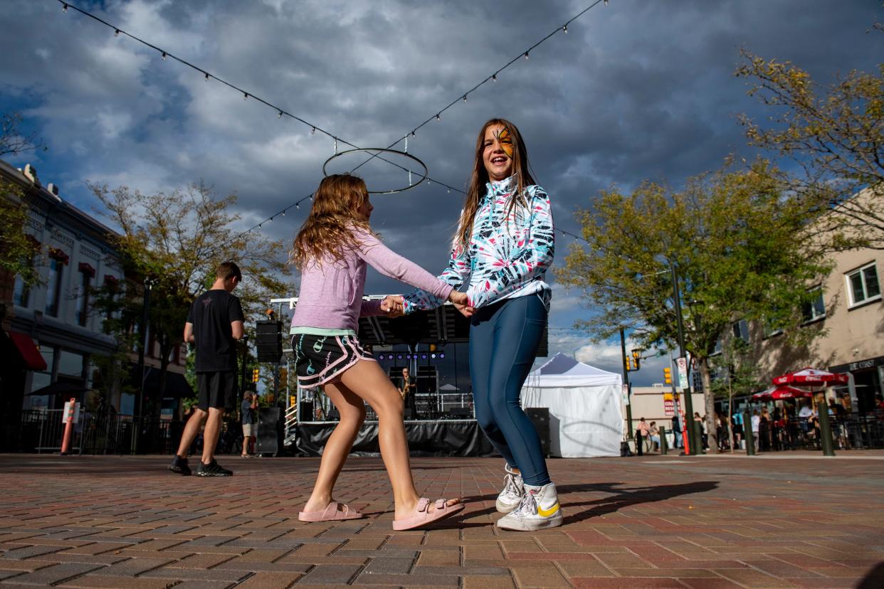 Zoey Gilbert, left, and Evelyn Townsend dance to the music of Downtown Michael Brown during an open street event on Linden Street in Old Town Fort Collins on Sept. 16, 2022.