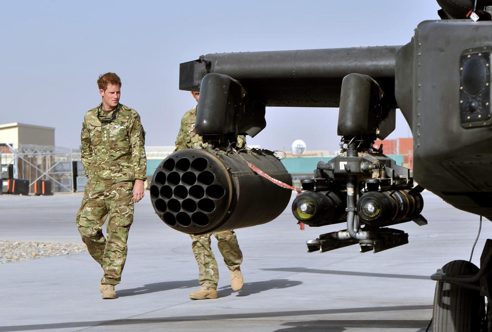 Britain's Prince Harry, left, is shown the Apache helicopter by a member of his squadron (name not provided) at Camp Bastion in Afghanistan, Friday Sept. 7, 2012. Prince Harry will be based at Camp Bastion during his tour of duty as a co-pilot gunner, returning to Afghanistan to fly attack helicopters in the fight against the Taliban. (AP Photo/John Stillwell)