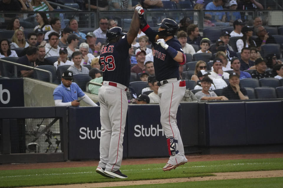 Boston Red Sox's Justin Turner, right, high-fives third base coach Carlos Febles after his solo home run in the second inning of a baseball game against the New York Yankees, Sunday, June 11, 2023, in New York. (AP Photo/Bebeto Matthews)