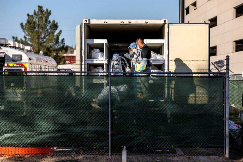 美國德州艾爾帕索新冠疫情嚴峻，法醫辦公室外圍停放一排冷藏貨車，充當行動停屍間。（圖／達志／路透社）