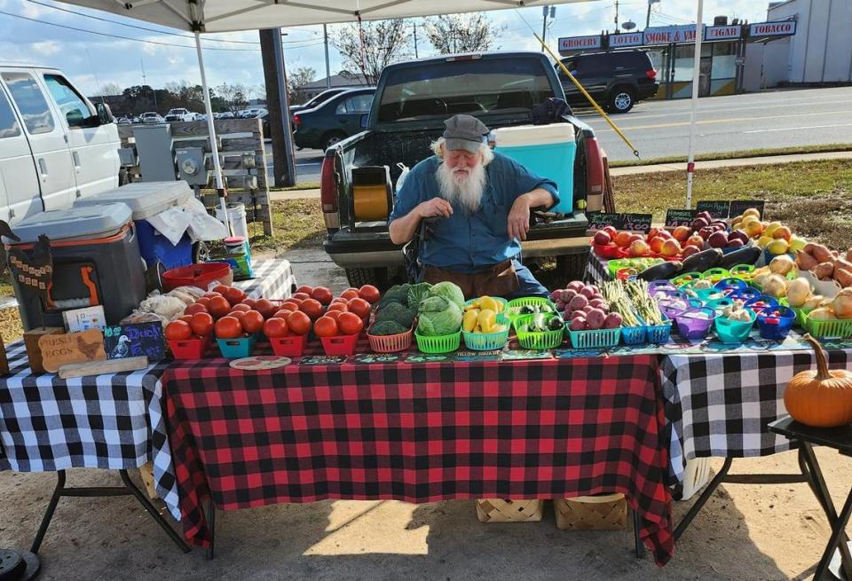 A farmer sells produce at the International City Farmers Market in Warner Robins. The market partners with several organizations to help feed the homeless.