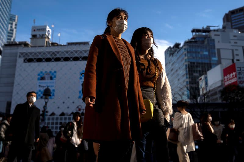 People wearing protective masks are seen at the scramble crossing in Shibuya shopping district, also known as Shibuya crossing, following an outbreak of the coronavirus in Tokyo