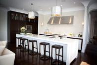 A chef's kitchen sits at the back of the room and includes a custom hood exhaust system set against a Venetian plaster wall. We love the Urban Electric sconces that provide extra mood lighting for entertaining. The oversize sink was even installed slightly offset so that views of the Golden Gate Bridge wouldn't be obstructed inside this renovated 1913 Edwardian. Source: Marsh & Clark Design