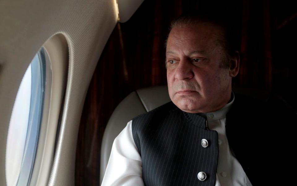 Pakistani Prime Minister Nawaz Sharif looks out the window of his plane after attending a ceremony to inaugurate the M9 motorway between Karachi and Hyderabad - Credit: REUTERS/Caren Firouz/File Photo