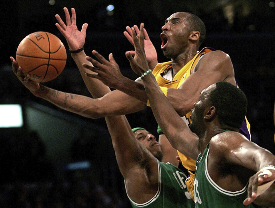 FILE - In this Feb. 23, 2007, file photo, Los Angeles Lakers' Kobe Bryant, top, goes up for a shot between Boston Celtics' Paul Pierce, left, and Al Jefferson during the first half of an NBA basketball game in Los Angeles. Kobe Bryant, Tim Duncan and Kevin Garnett are all expected to be officially announced as members of the 2020 enshrinement class for the Basketball Hall of Fame on Saturday, April 4, 2020. (AP Photo/Branimir Kvartuc, File)