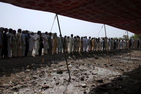 Men fleeing from a military offensive against Pakistani militants in North Waziristan queue to get relief handouts from a storage tent of the World Food Programme (WFP) at a distribution point for internally displaced persons (IDP) in Bannu, located in Pakistan's Khyber-Pakhtunkhwa province, in this July 6, 2014 file photo. REUTERS/Khuram Parvez/Files