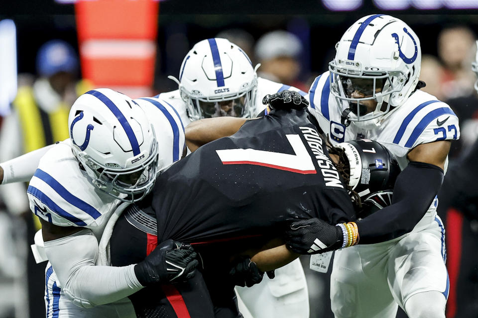 Indianapolis Colts defensive end Kwity Paye (51) and Indianapolis Colts cornerback Kenny Moore II (23) hit Atlanta Falcons running back Bijan Robinson (7) during the first half of an NFL football game, Sunday, Dec. 24, 2023, in Atlanta. (AP Photo/Alex Slitz)
