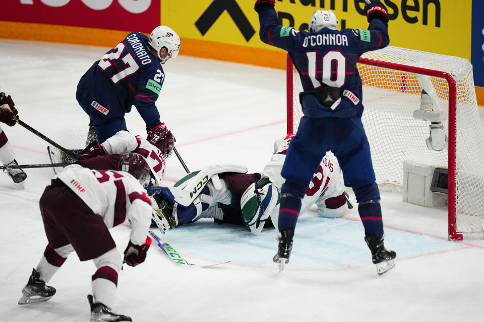 United States Drew O'Connor (10) celebrates as Matt Coronato (27) scores on Latvia's goalie Arturs Silovs (31) in their bronze medal match at the Ice Hockey World Championship in Tampere, Finland, Sunday, May 28, 2023. (AP Photo/Pavel Golovkin)