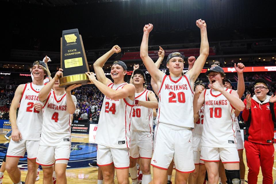 Dallas Center-Grimes players raise the trophy after defeating Central DeWitt during the Class 3A Iowa high school boys basketball championship game at Wells Fargo Arena Friday, March 11, 2022, in Des Moines.
