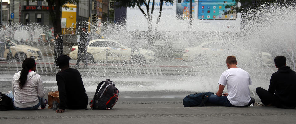 Menschen an einem Brunnen in München (Bild: Reuters/Michael Dalder)