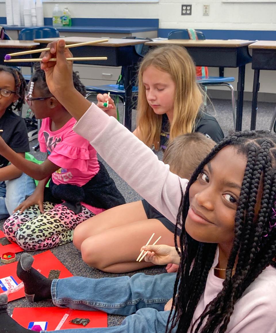 Kingsfield Elementary School students practice using chopsticks during the Let's Visit Japan after school program run by The Global Corner.