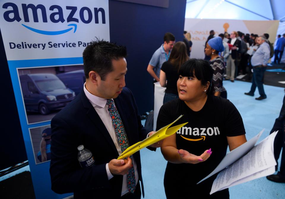 An Amazon recruiter (R) gives advice to a job seeker at an Amazon Career Day event, where recruiters help candidates build interview skills, prepare them for job interviews and give them more information on the roles within the company, at Crystal City in Arlington, Virginia on September 17, 2019. - Amazon is aiming to hire more than 30,000 people across the country by early next year. (Photo by Andrew CABALLERO-REYNOLDS / AFP)        (Photo credit should read ANDREW CABALLERO-REYNOLDS/AFP via Getty Images)