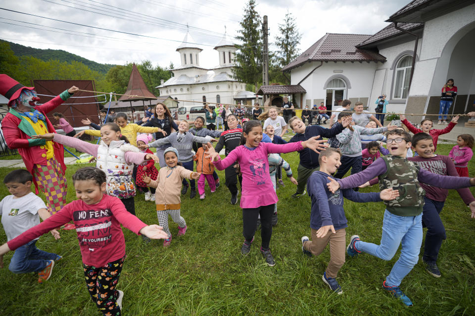 Children play during an eyesight examination performed by volunteer ophthalmologists, in Nucsoara, Romania, Saturday, May 29, 2021. Dozens of disadvantaged young Romanian children got a chance to get their eyesight examined for the first time in their lives during an event arranged by humanitarian organization Casa Buna, or Good House, which has played a prominent role in supporting the local children's lives throughout the pandemic. (AP Photo/Vadim Ghirda)