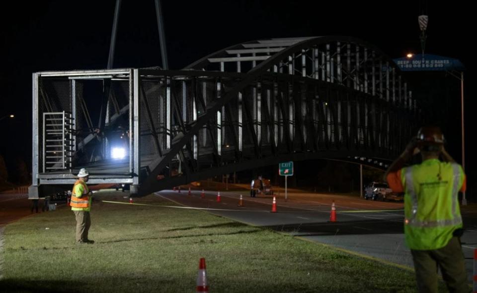 Construction workers take measurements while moving a pedestrian bridge at Hurlburt Field last October. The repairs had been expected to take six months, but issues discovered during ultrasonic testing of the structure could stretch that timeline.