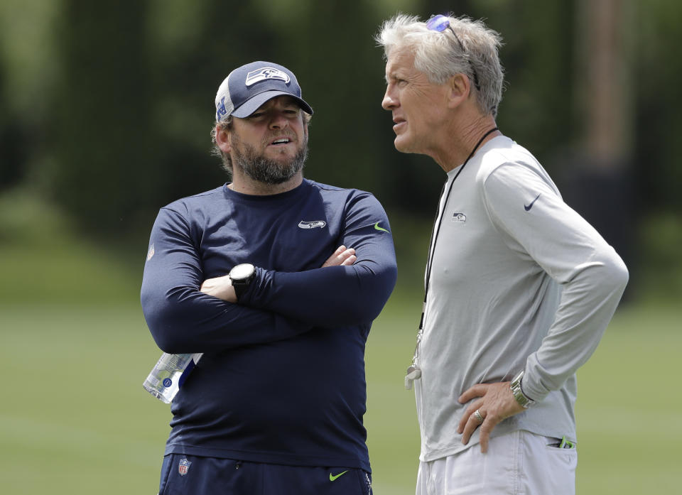 Seattle Seahawks head coach Pete Carroll, right, talks with general manager John Schneider, left, following an organized team activity, Thursday, June 6, 2019, at the team's NFL football training facility in Renton, Wash. (AP Photo/Ted S. Warren)