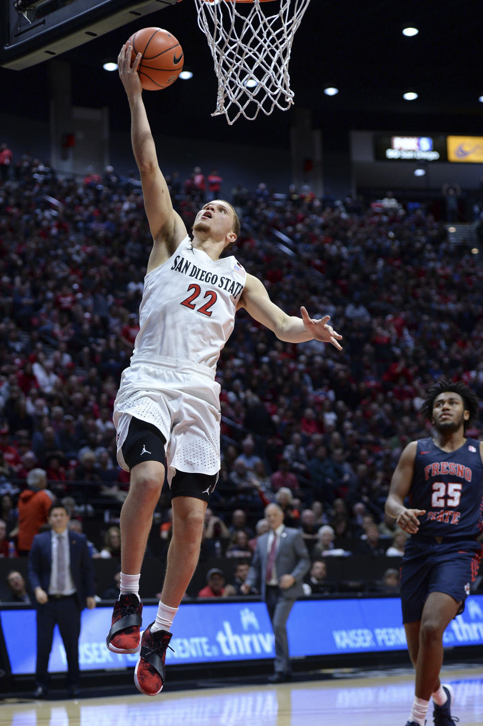 San Diego State guard Malachi Flynn (22) goes to the basket as Fresno State guard Anthony Holland (25) looks on during the second half of an NCAA college basketball game Wednesday, Jan. 1, 2020, in San Diego. San Diego won 61-52. (AP Photo/Orlando Ramirez)