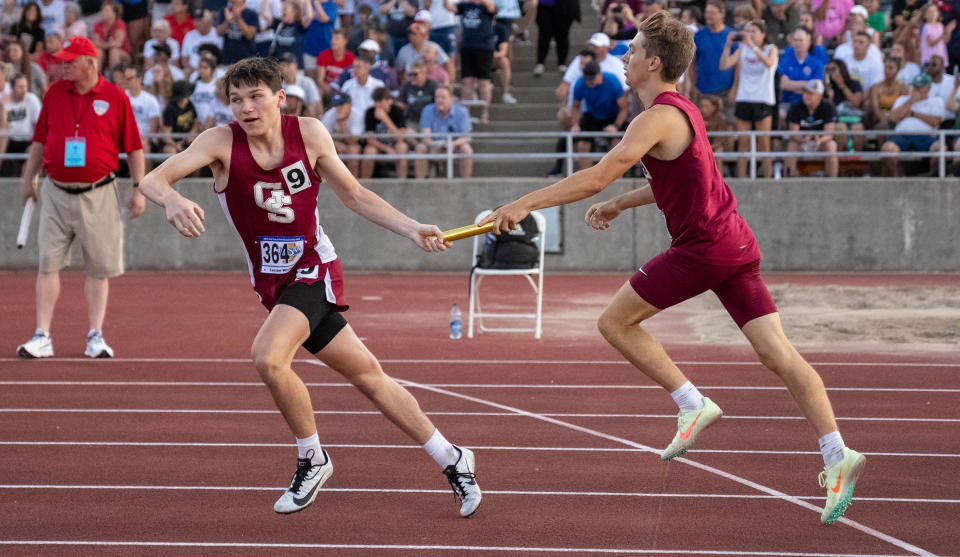 Gibson Southern’s Connor Wirey hands Lucian Wicker the baton during the 1600 meter relay Friday, June 2, 2023, during the IHSAA boys track and field state finals at Robert C. Haugh Track and Field Complex at Indiana University in Bloomington.