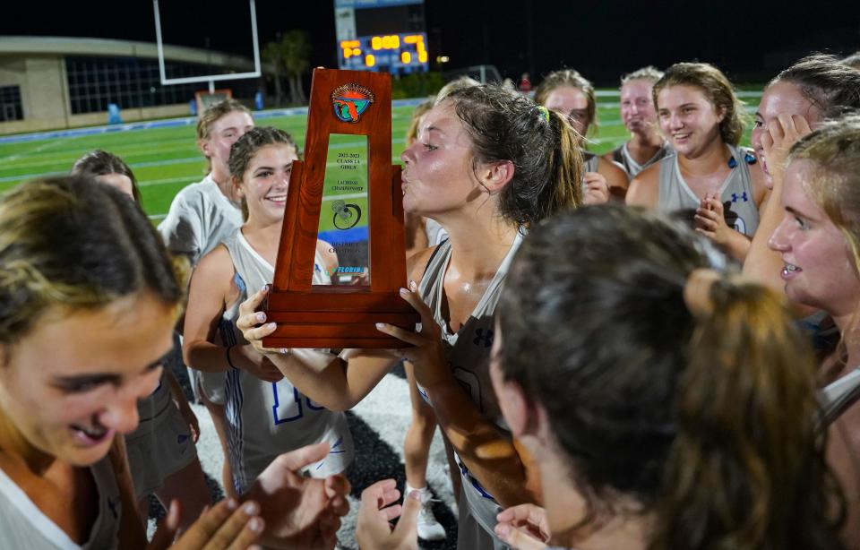 Community School of Naples Seahawks attacker Tatum Kocaj (18) kisses the trophy after the team defeated the Barron Collier Cougars in the Class 1A District 12 final at Community School of Naples in Naples on Thursday, April 13, 2023. 