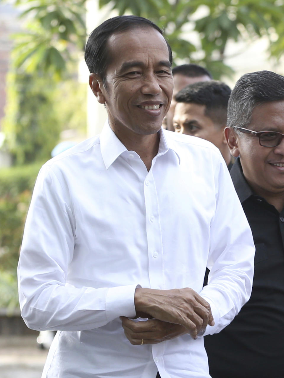 Incumbent Indonesian President Joko Widodo walks with Secretary General of Indonesian Democratic Party-Struggle Hasto Kristiyanto, right, upon arrival for a meeting with leaders of his coalition parties in Jakarta, Indonesia, Thursday, April 18, 2019. Widodo said Thursday he was won re-election after receiving an estimated 54% of the vote, backtracking on an earlier vow to wait for official results after his challenger made improbable claims of victory. (AP Photo/Achmad Ibrahim)