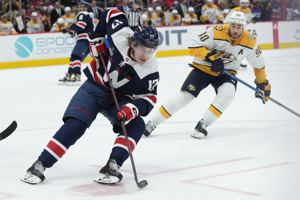 Washington Capitals center Dylan Strome (17) digs out the puck before Nashville Predators center Ryan O'Reilly (90) can get it during the second period of an NHL hockey game in Washington, Saturday, Dec. 30, 2023. (AP Photo/Susan Walsh)