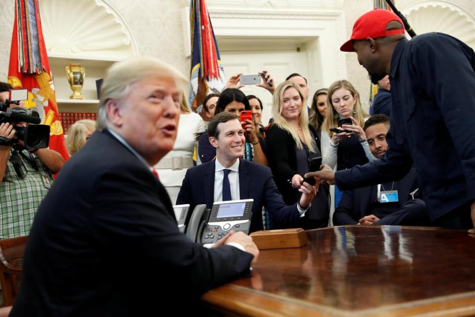 Rapper Kanye West shows a photo on his mobile phone to White House senior adviser Jared Kushner  during a meeting with U.S. President Donald Trump (REUTERS/Kevin Lamarque)