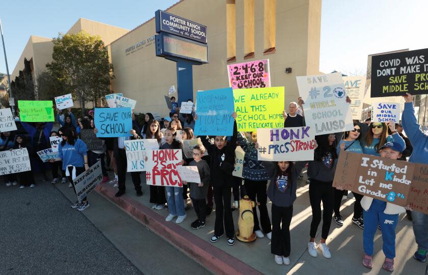 Parents and students hold signs outside Porter Ranch Community School.