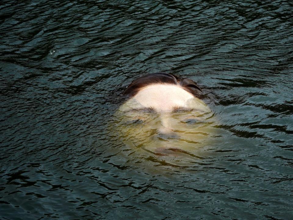 A fiberglass sculpture entitled "Bihar" ("Tomorrow" in Basque), by Mexican hyperrealist artist Ruben Orozco, is submerged in the Nervion river in Bilbao, Spain, September 27, 2021.