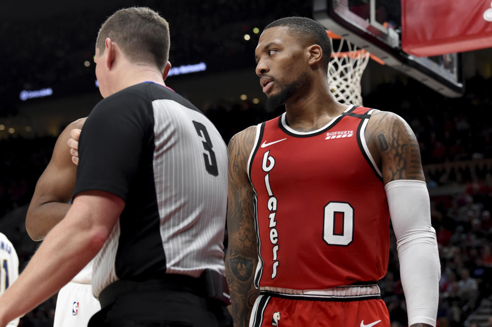 Portland Trail Blazers guard Damian Lillard, right, has some words with referee Nick Buchert, left, during the second half of an NBA basketball game in Portland, Ore., Sunday, Jan. 26, 2020. Lillard scored 50 points as the Blazers won 139-129. (AP Photo/Steve Dykes)