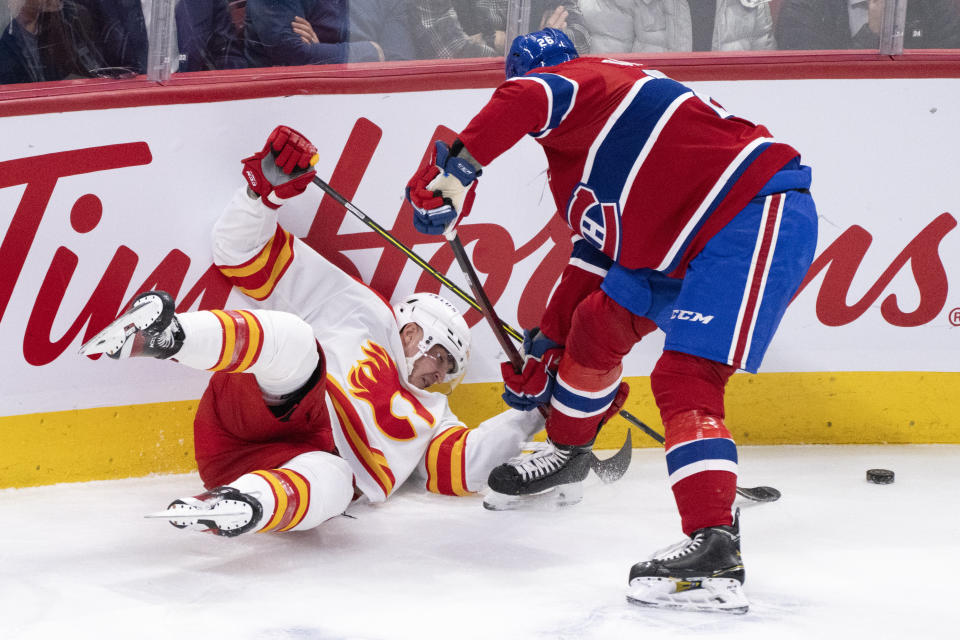 Calgary Flames' Trevor Lewis is dumped by Montreal Canadiens' Johnathan Kovacevic during second-period NHL hockey game action in Montreal, Monday, Dec. 12, 2022. (Paul Chiasson/The Canadian Press via AP)