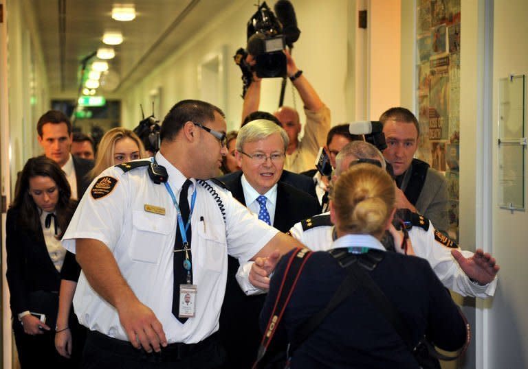 Former Australian prime minister Kevin Rudd (centre) is surrounded by security guards and members of the media at Canberra's Parliament House, on June 26, 2013. Rudd has ousted Prime Minister Julia Gillard as head of Australia's Labor Party in a bitter leadership ballot